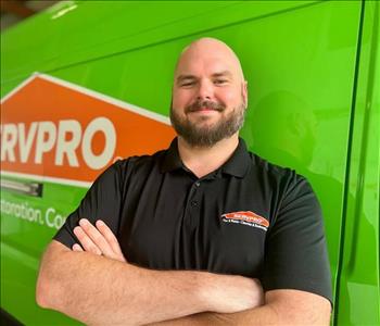 Project Manager Standing in front of Servpro Fleet