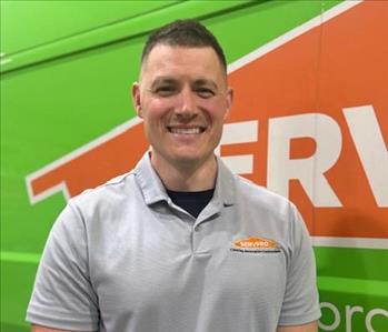 Man standing in front of green vehicle 